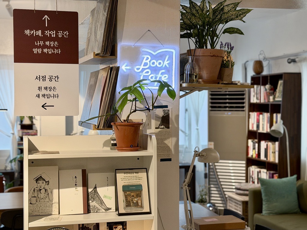 Book Cafe 네온과 화분, 책이 놓인 책카페 선반