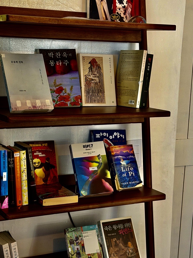 원목 선반에 표지가 보이게 세워 둔 책들