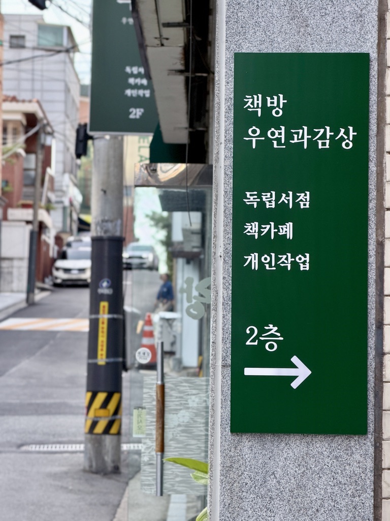 건물 입구의 초록 안내판: 책방 우연과감상, 독립서점·책카페·개인작업, 2층